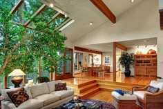 a living room filled with furniture and a tree in the middle of it's center