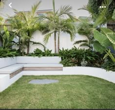 a white bench sitting in the middle of a lush green yard