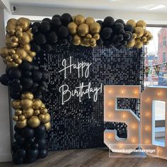 a black and gold 50th birthday party with balloons