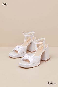 We recommend styling the Lulus Remie White Satin Knotted Platform High Heel Sandals with any look that needs an extra dash of fabulousness! Sleek woven satin shapes these iconic heels that feature a trendy square footbed (atop a 0.75"" toe platform) and gather straps that create a wide, knotted peep-toe upper. A matching quarter strap secures around ankle with a gold buckle, all atop a chunky block heel. 3. 5" wrapped block heel. Lightly cushioned insole. Felted rubber sole has nonskid markings. Man Made Materials. Imported. Lulus | Remie White Satin Knotted Platform High Heel Sandal Heels. Ivory Block Heels, Iconic Heels, Low Chunky Heels, Casual Formal Dresses, Lulu Fashion, White Platform, Satin Heels, Sandal Heels, Chunky Block Heels