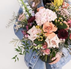 a woman holding a bouquet of flowers in her hands