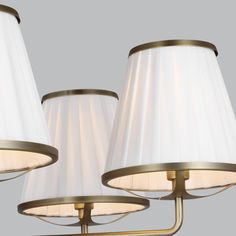 three lamps with white shades on each one