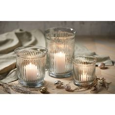 three clear glass candles sitting on top of a wooden table