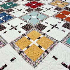 a quilted table topper with different colored squares on it