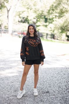 Black terry knit pullover accented with embroidered footballs and 'touchdown' In the Fall we are all Touchdown Obsessed!! Show your gameday spirit in this fabulous black sweatshirt, featuring brown embroidery braided footballs and the word 'touchdown' on the front and down the sleeves. With a crew neckline and long balloon sleeves, she's as comfy as she is festive. Tailgating never looked so stylish! True to size fit; relaxed silhouette Model is 5'5" wearing a small Fabric contains stretch Ribbe Football Party Outfit, Tailgating Outfits, Brown Embroidery, Tailgate Outfit, Graphic Tee Dress, Football Sweatshirt, Football Party, Vintage Couture, Black Sweatshirt