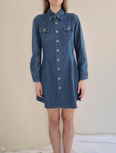 "1990s long sleeve, two front chest pockets, two pockets on back, hits just above the knee tagged size large, I think it fits a bit more like a medium, see measurements for fit measurements: length 33\", waist 32\", pit-to-pit 19\"  100% cotton, machine wash, made in USA excellent pre-owned condition, no flaws or damage Feel free to bundle with other items Items are pre-owned with possible flaws as expected with vintage. Major flaws will be noted in description." Long Sleeve Denim Dress With Button Closure, Long Sleeve Denim Dress With Buttons, Long Sleeve Dark Wash Denim Dress, Long Sleeve Dark Wash Denim Dress With Buttons, Blue Long Sleeve Denim Dress With Buttoned Pockets, Casual Long Sleeve Denim Dress With Pockets, Fitted Long Sleeve Denim Dress With Pockets, Fitted Long Sleeve Denim Dress With Button Closure, Long Sleeve Cotton Denim Dress