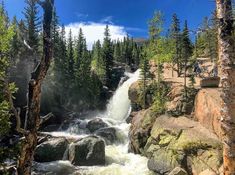 a large waterfall surrounded by trees and rocks