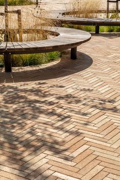 a wooden bench sitting on top of a brick walkway