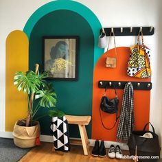 a colorful entryway with an arch, potted plant and purses hanging on hooks