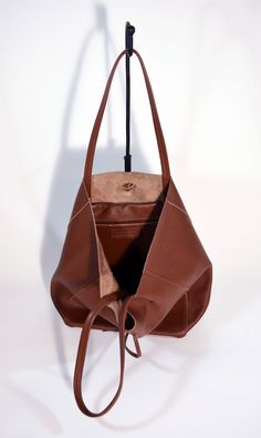 A lightweight and spacious Leather Shopper Bag-Tan you can use for your office, gym and after-hours essentials while still looking stylish. Handmade from supple calfskin Italian leather, the versatile look features over-the-shoulder handles and minimal detailing. Raw edges and no lining makes this style super light and easy to fold when traveling. Inside is a zippered document pouch and a leather cell phone pouch. Details: Color: TanTwo leather strap for closing the bag.Natural unlined interiorM Versatile Cognac Shoulder Bag For Daily Use, Versatile Cognac Shoulder Bag With Smooth Grain, Versatile Cognac Bag With Smooth Grain, Cognac Smooth Grain Versatile Shoulder Bag, Leather Handled Hobo Tote Bag For Business, Leather Hobo Tote Bag For Business, Business Hobo Bag With Leather Handles, Versatile Cognac Leather Shoulder Bag, Versatile Everyday Bucket Bag With Leather Lining