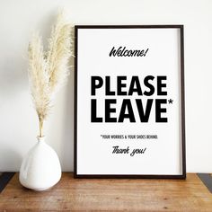 there is a sign that says welcome please leave and a vase with a plant in it