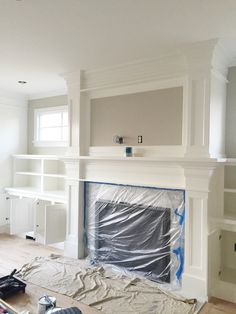 a living room that has been painted white and is being worked on by the fireplace mantel