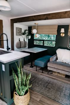 the interior of a mobile home with a couch, table and kitchenette in it