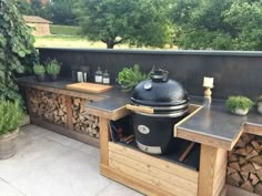 an outdoor bbq grill with potted plants on it