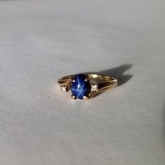 Vintage Mid Century 10 kt Gold Blue Star Sapphire & Diamond Ring Features: Absolutely beautiful ring! Two small diamonds accent the royal blue star sapphire. Beautiful star when then light reflects! Stamped 10 kt on interior of band. Claw settings. Condition: Excellent. Little to no signs of wear. Stones are present, securely mounted, and unblemished. Era: Mid Century, circa 1945 Size: 7.5 US Star Saphire Ring, Mid Century Ring, Sapphire Pinky Ring, Blue Star Ring, Sapphire Vintage Ring, Elegant Star-shaped Sapphire Ring For Anniversary, Safire Rings, Sapphire Ring Vintage, Blue Star Sapphire Ring