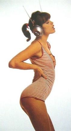 a woman in a bathing suit with headphones on