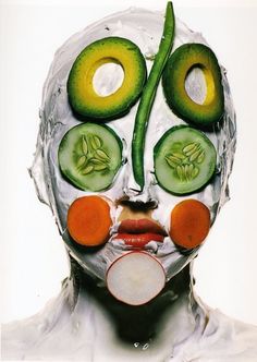 a man with vegetables painted on his face and the image is made up of cucumbers