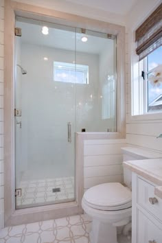 a bathroom with a shower, toilet and sink in it's corner area next to a window