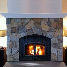 a fire place in a living room with two lamps on either side of the fireplace