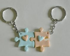 two pieces of puzzle sitting on top of each other in the shape of a keychain