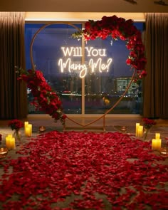 a valentine's day display with roses and candles in front of a window that says will you marry me?