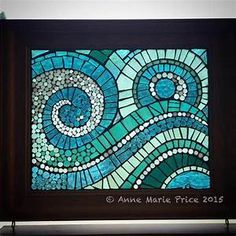 a blue and green stained glass window with swirls in the center on a shelf