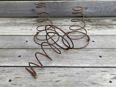 a metal sculpture sitting on top of a wooden floor next to a fence and grass