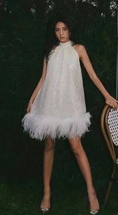 "Beautiful sequin and pearl A line mini dress with ostrich feather trim. Mock neck with back tie. Oversized fit. 3 layers of ostrich feather trim.  One size- fits up to a 50\" Bust  Length approx 27\" * Sizing - All items are made according to measurement ranges, they are NOT typical letter or numeric sizing. It is imperative to compare your exact measurements with the size chart provided either in the listing photos or item descriptions and to also add your measurements under Personalization. I A Line Mini Dress, Ostrich Feather Trim, Feather Jacket, White Halter Dress, Feather Tops, Pearl Dress, Feather Trim, Ostrich Feather, Feather Dress