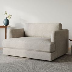 a white chair sitting on top of a carpeted floor next to a wooden table