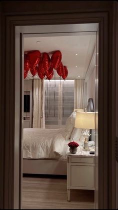 a bedroom with red balloons hanging from the ceiling