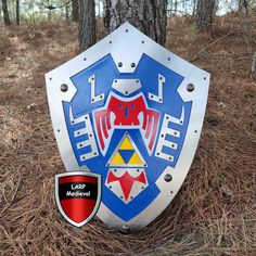 a blue and white shield sitting in the middle of a forest