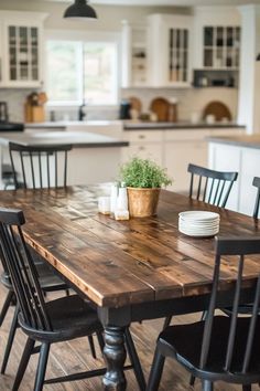 a kitchen table with chairs around it and a potted plant in the center on top