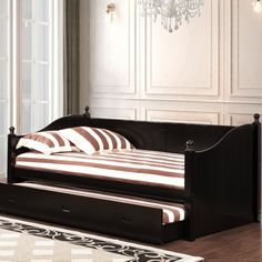 a day bed with a pull out trundle in a room that has hardwood floors and white walls