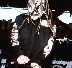 a man with dreadlocks sitting on a stage