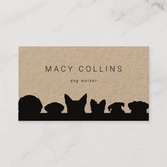 a business card with silhouettes of dogs and cats on it, sitting in front of a marble background