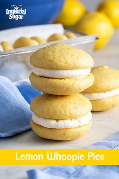 lemon whoopie pies stacked on top of each other in front of some lemons