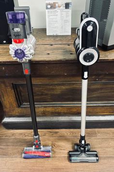 two vacuums are sitting on the floor next to each other