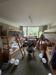 there are many bunk beds in this room and one person is reaching up to the ceiling