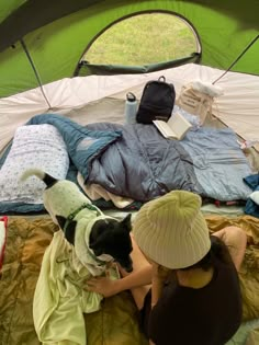 a woman and her dog sitting on a bed in a tent