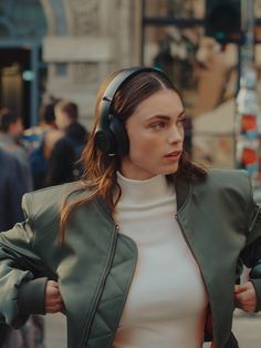 a woman with headphones on walking down the street