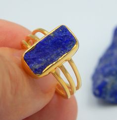 Lapis Lazuli Rectangle Rough Gemstone Ring made out of 18 karat Gold plated Sterling Silver. 100% Handmade Jewellery. LAPIS LAZULI: The sweet sounding, melodic name of this gem is composed of 'Lapis', the Latin word for stone, and 'Azula', which comes from the Arabic and means 'blue'. Historians believe the link between humans and lapis lazuli stretches back more than 6,500 years. The gem was treasured by the ancient civilizations of Mesopotamia, Egypt, China, Greece, and Rome. They valued it fo Gold Sapphire Ring With Rectangular Stone As Gift, Rectangular Gold Sapphire Ring Gift, Rectangular Sapphire Ring In Gold Setting, Yellow Gold Sapphire Ring With Rectangular Stone For Gift, Elegant Rectangular Rings With Natural Stones, Elegant Rectangular Natural Stone Rings, Rectangular Sapphire Ring Gift, Minimalist Blue Rectangular Ring, Rectangular Gemstone Rings For Gifts