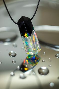 a necklace that has been placed on top of water and is hanging from a cord