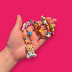 Bring some whimsy to your outfit with our Critter Bead Necklace, adorned with a charming Calico Critter. Each necklace is one-of-a-kind, handmade in Manchester, UK with varying colors and beads for a unique touch. Elastic thread and a clasp closure make it easy to wear. Rainbow Kittens, Calico Critter, Elastic Thread, Stretchy Bracelets, Craft Patterns, Beaded Necklaces, Bead Necklace, Needle Felting, Manchester