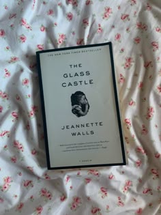 the glass castle by jeanette walls on a bed with pink and green floral sheets