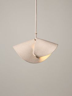 a light fixture hanging from a ceiling with a white wall in the background and a gray wall behind it