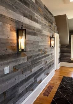 a wooden wall with two lanterns on the side and a rug in front of it