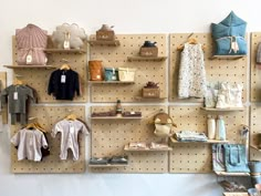 a pegboard with clothes and shoes on it in front of a wall filled with shelves