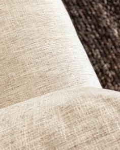 a close up view of the back end of a couch with an area rug in the background