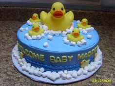 a baby shower cake decorated with rubber ducks