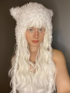 a woman with long white hair wearing a furry hat